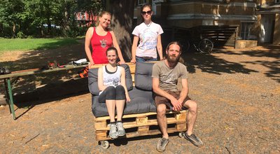 Eine Pallettencouch und ihre Erbauer*innen