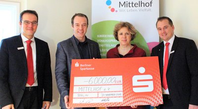 Sparkassen-Mitarbeiter übergeben der Mittelhof Geschäftsführung PS-Sparen Scheck für das Projekt "Barrierefreie Selbsthilfe-Website"
