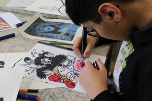 Jugendlicher zeichnet ein Manga