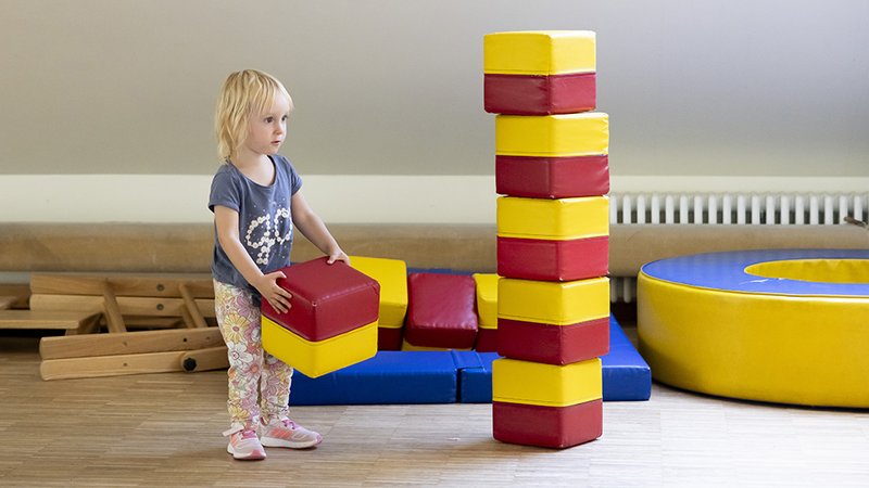 Kind mit gestapelten Bausteinen in der Spielgruppe des Familienzentrums in der Bewegungsetage